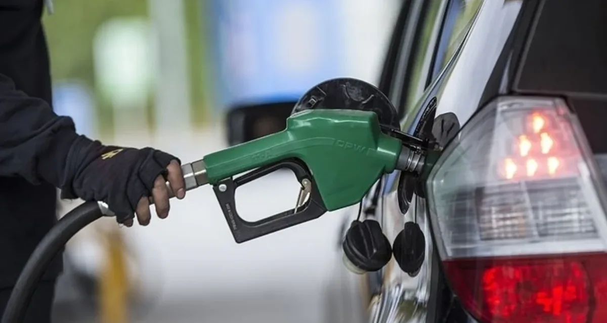 Pompa fiyatlarını gösteren akaryakıt istasyonu tabelası ve araçlar